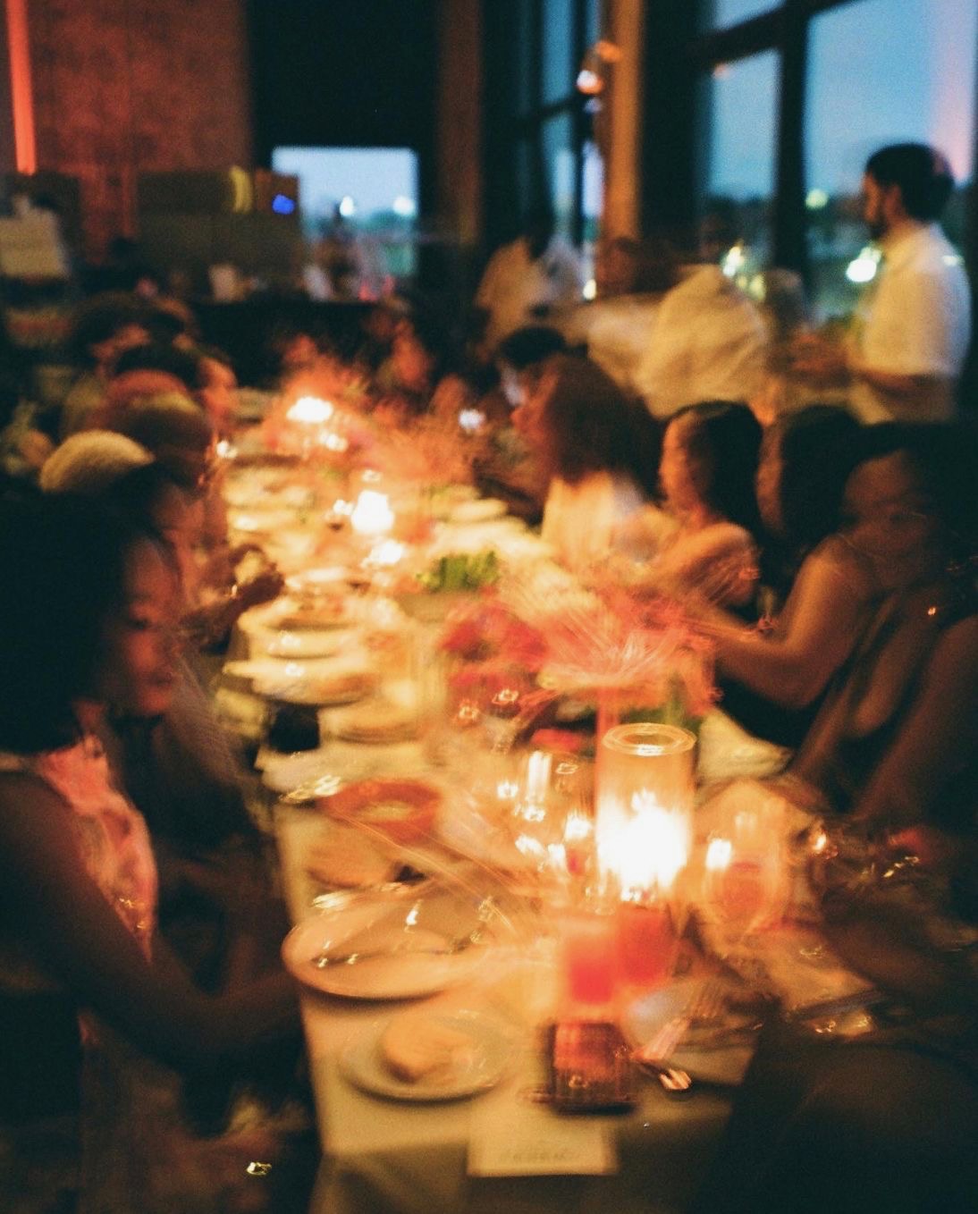 Candlelit guests gathered around a long table