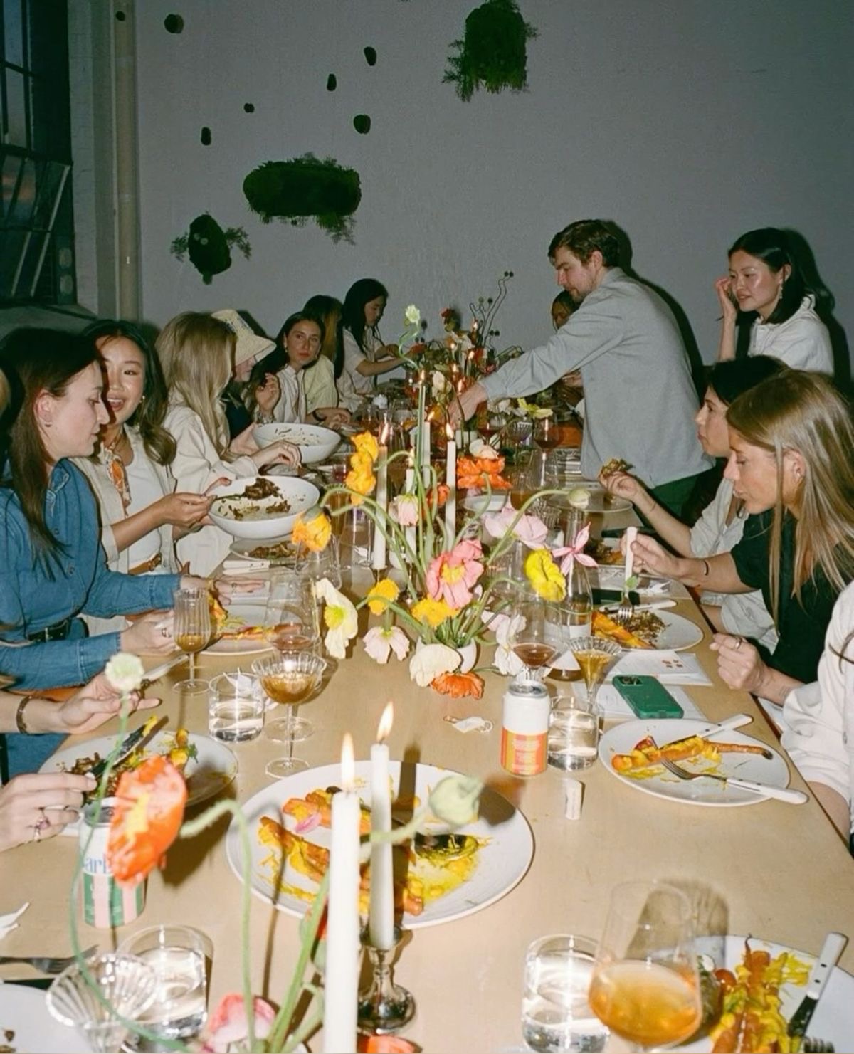 Guests seated at a long table as food is served